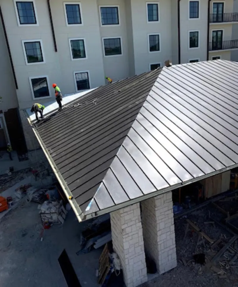 Crew installing standing seam metal roof panels on a commercial project in Owings Mills